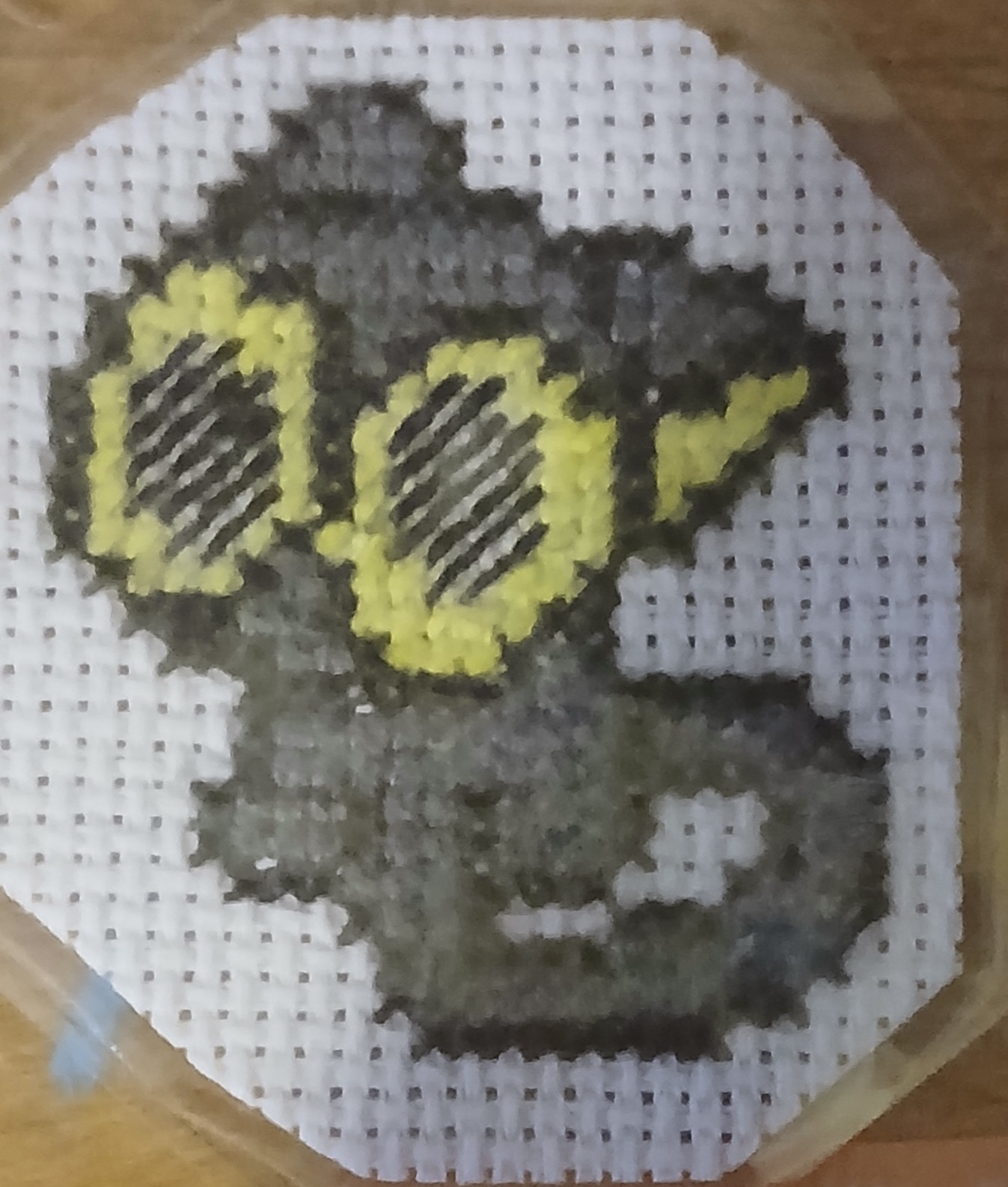 A cross stitch of a cat with huge eyes