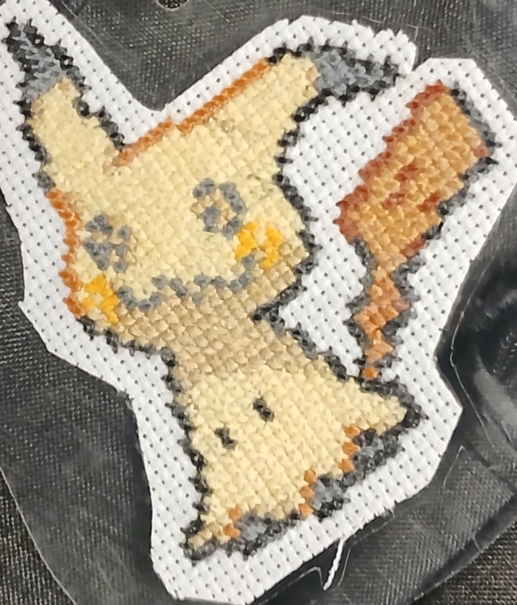 A cross stitch of Mimikyu